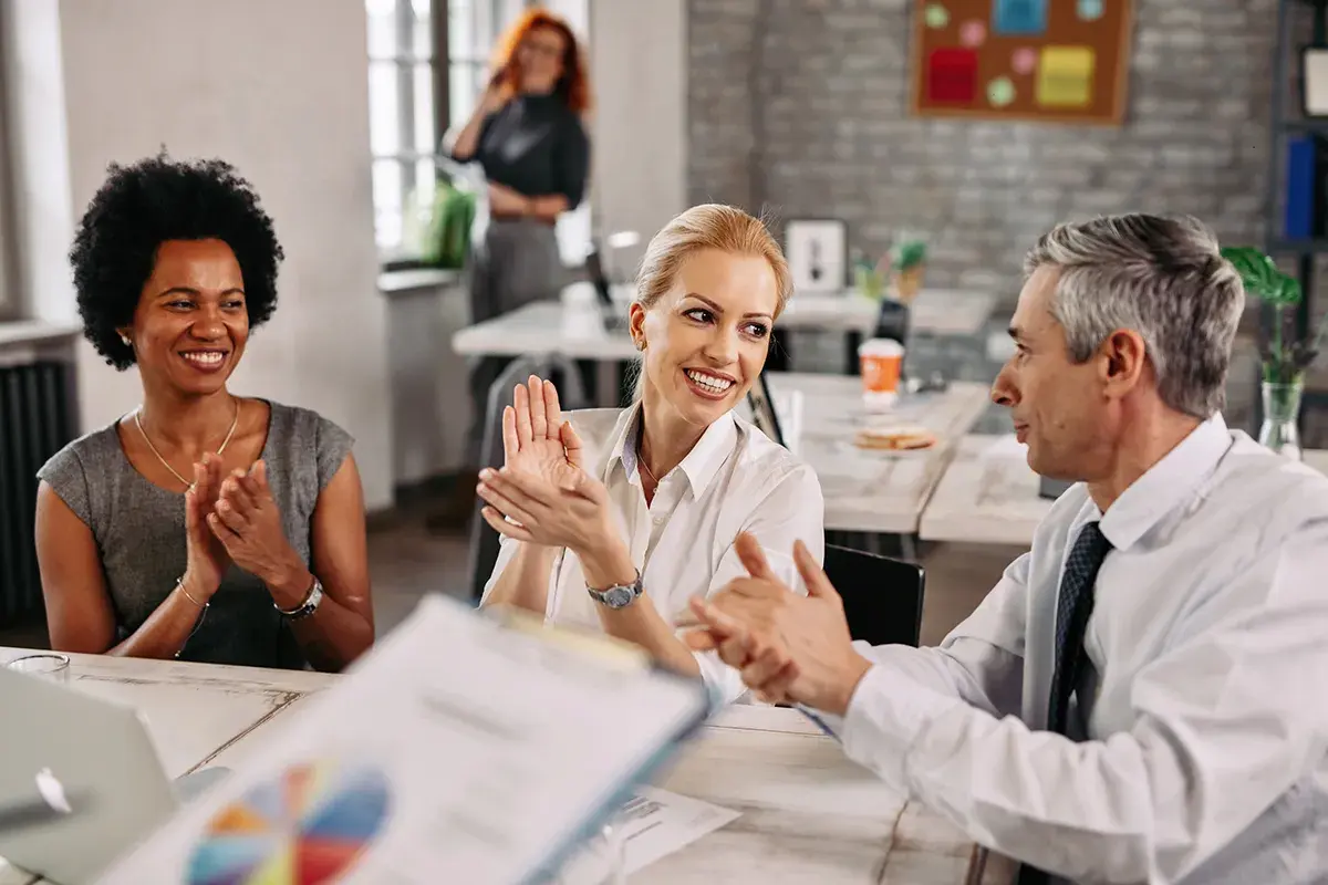 Business team applauding and celebrating success during a collaborative meeting in a modern office