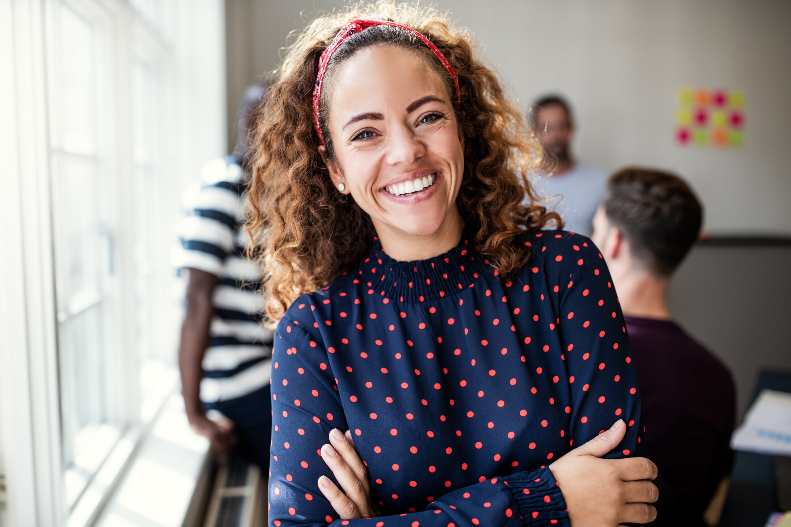 Woman in polka dot blouse, confident.